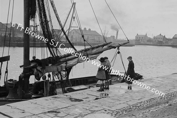 CHILDREN LOOKING AT BOAT IN HARBOUR